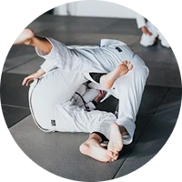 Séance de groupe dans un dojo, mouvement technique de lutte sur tapis.